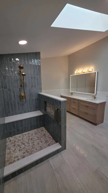 Bathroom with walk-in shower, skylight and wood vanity