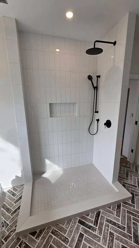 White tiled shower with a built-in bench