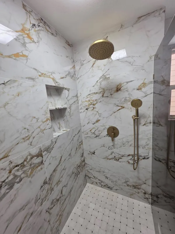 Marble-look shower tile with gold-coloured fixtures