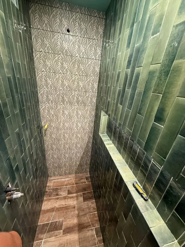 Green tiled shower with contrasting floor tile
