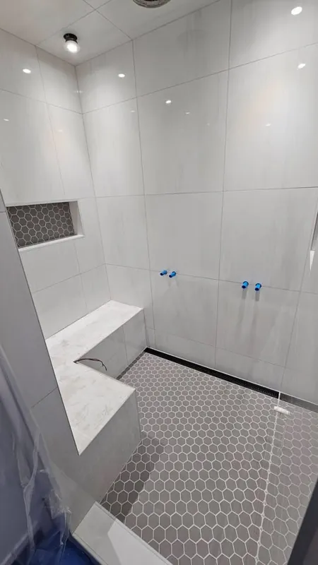 White shower tile, recessed niche and mosaic floor