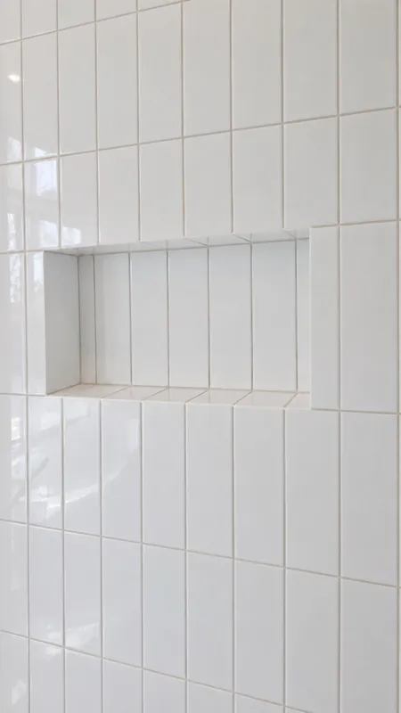 White wall tile and a recessed shower niche