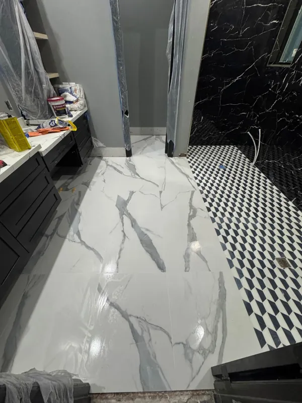 Marble-look bathroom floor beside dark wall tile