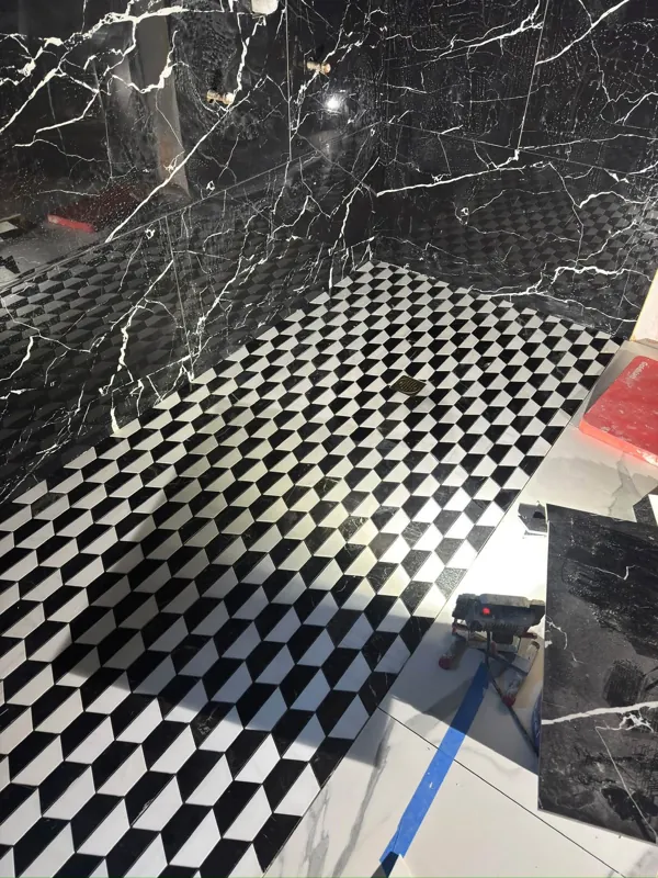 Geometric shower floor and dark marble-look walls