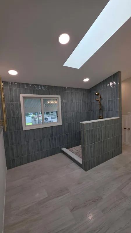 Bathroom with skylight and dark tiled shower