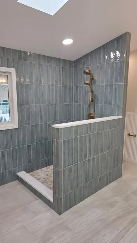 Walk-in shower with dark wall tile and half wall