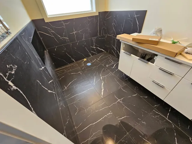 Bathroom with dark tile and white vanity
