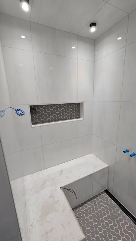 White shower walls and mosaic shower floor
